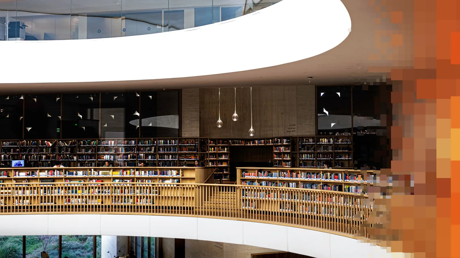 Bibliotek med buede balkonger og bokhyller i flere etasjer rundt et åpent rom