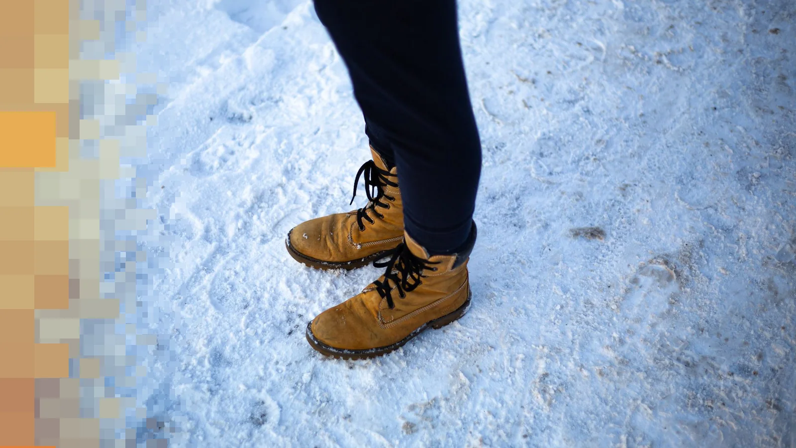 Gule vintersko i snø ved siden av mørke bukser