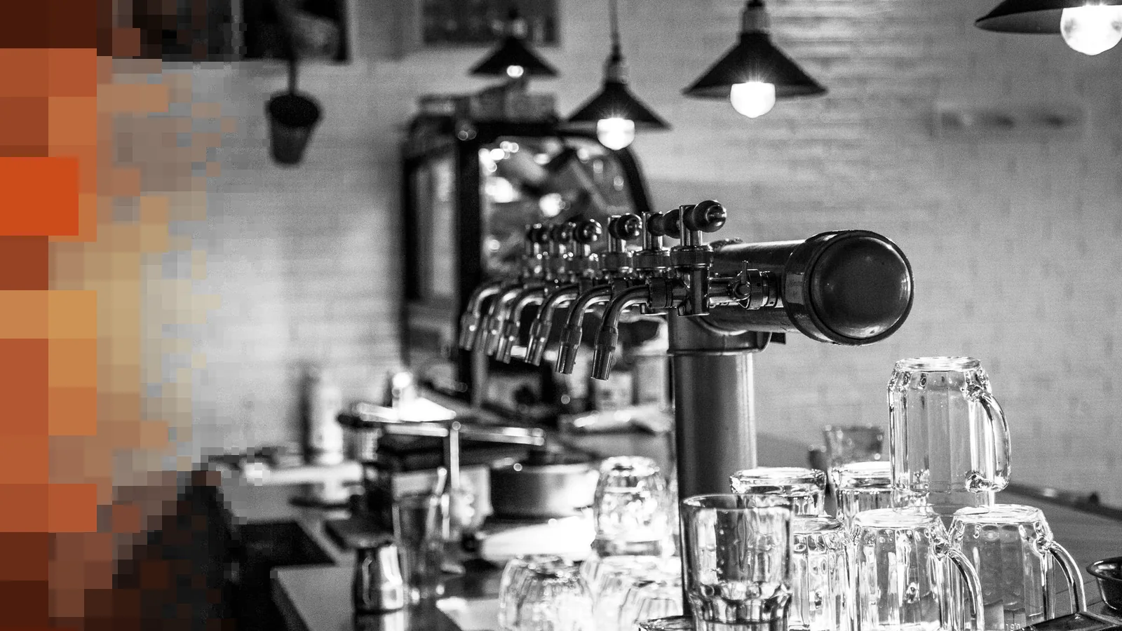 Svart-hvitt bilde av en bardisk med ølkraner, glass og taklamper