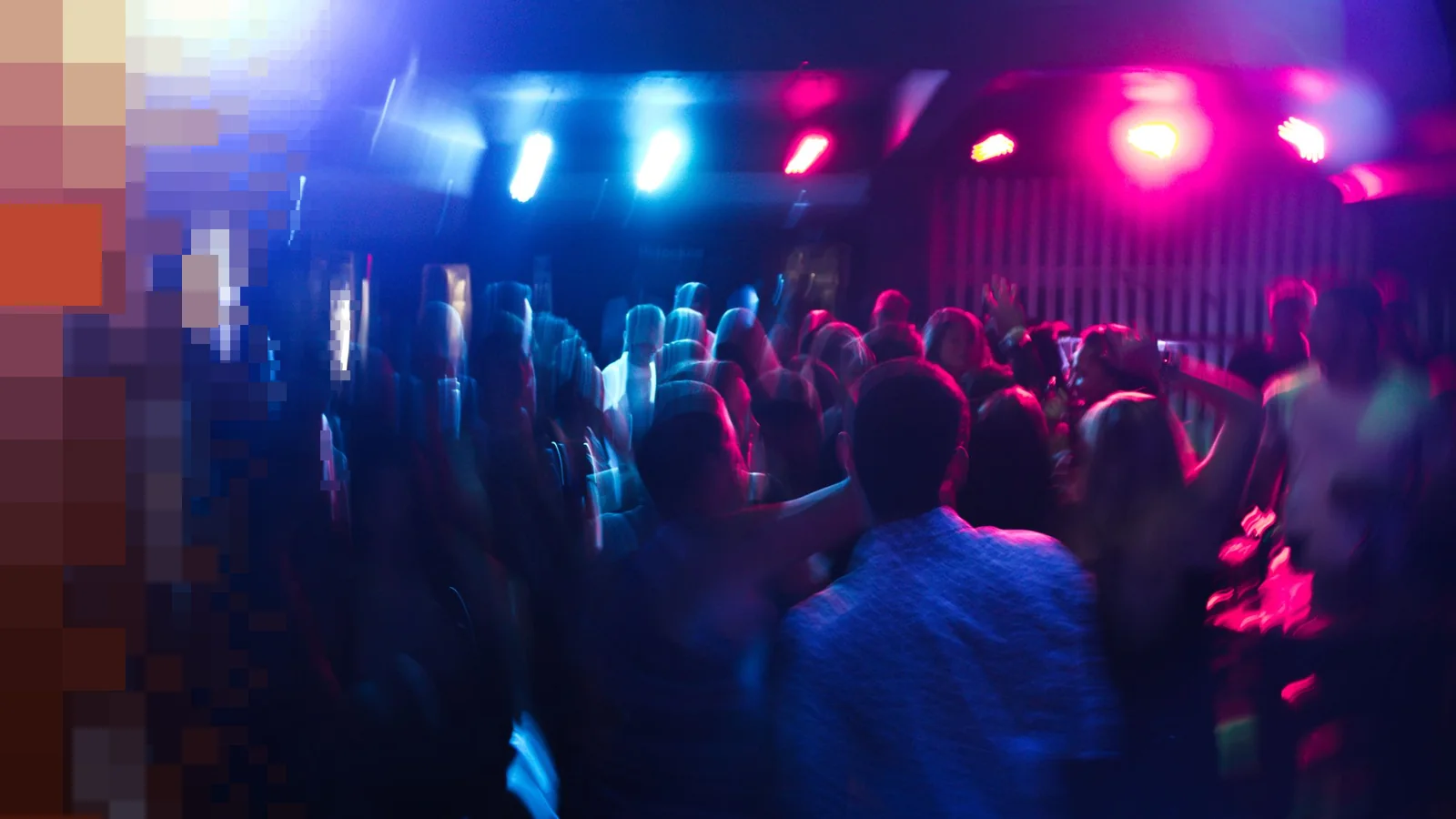 Uskarpt klubbpublikum som danser under rosa og blå lyskastere