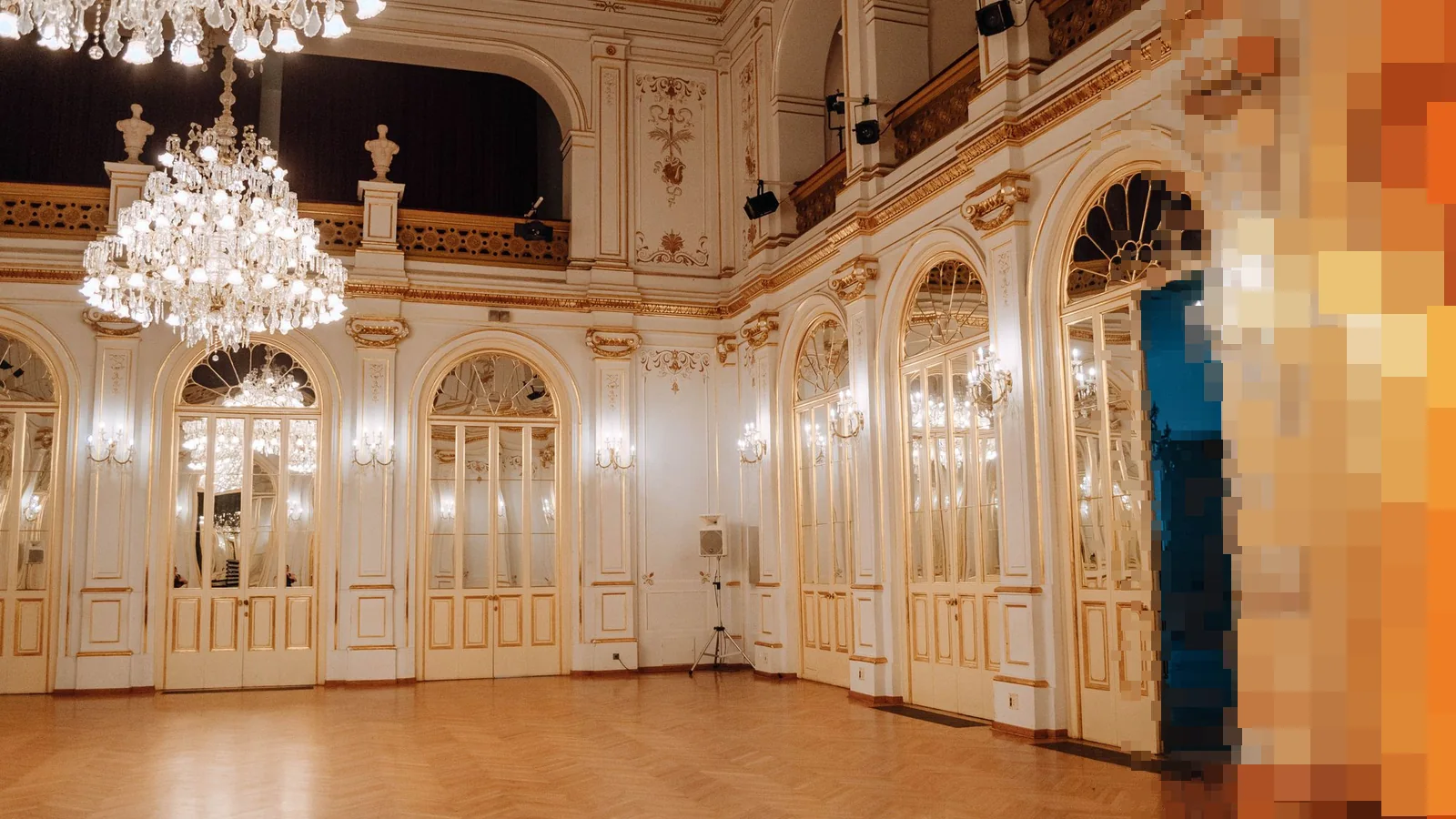 Stor festsal med krystallkroner, høye speilvinduer og parkettgulv, klar for en konsert