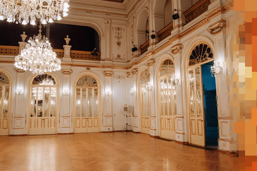 Stor festsal med krystallkroner, høye speilvinduer og parkettgulv, klar for en konsert