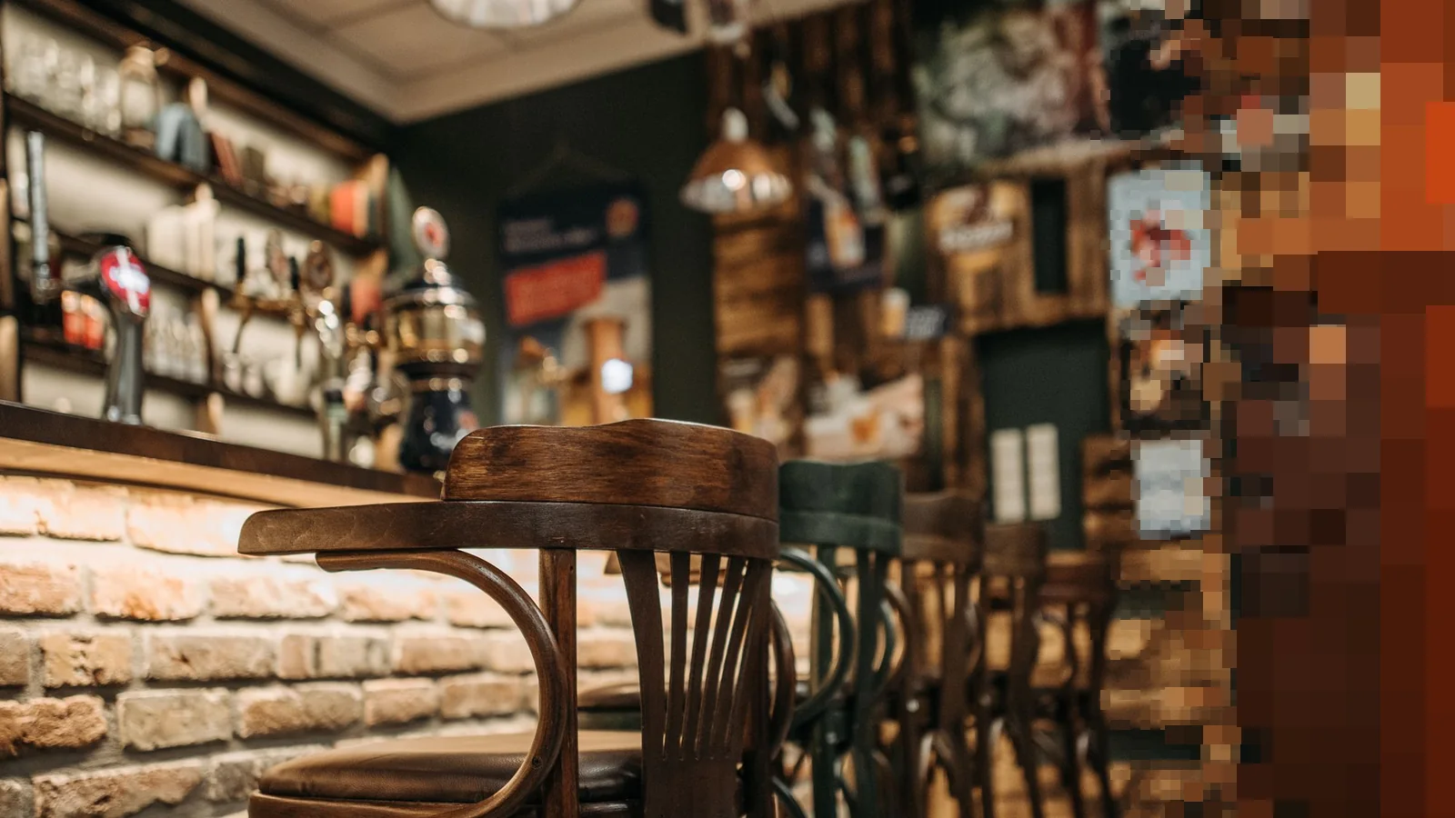 Tomme barkrakker i mørkt tre langs en bardisk med teglstein i en lun pub