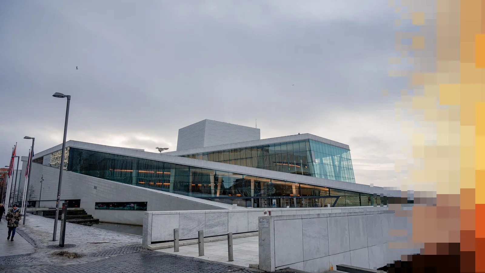 Operaen i Oslo en grå vinterdag, med hvit marmor, glassfasade og en brosteinsplass foran